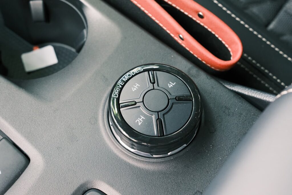 Car's drive mode selector and accessories are shown.